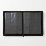 A black trading card binder lies open on a white background, showing two pages with nine clear pockets each.