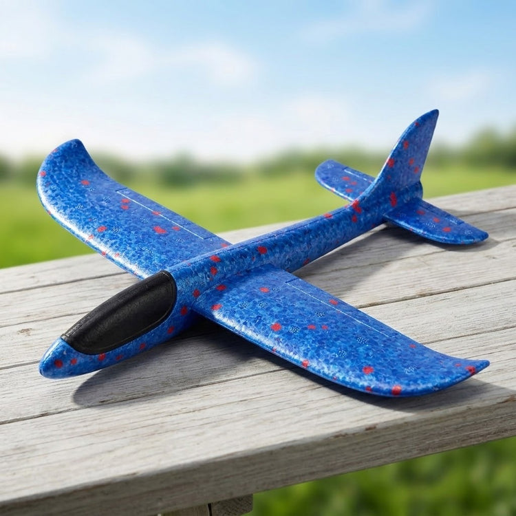 Blue foam glider option for an airplane launcher toy, with red speckles and a black cockpit, resting on weathered outdoor wood.