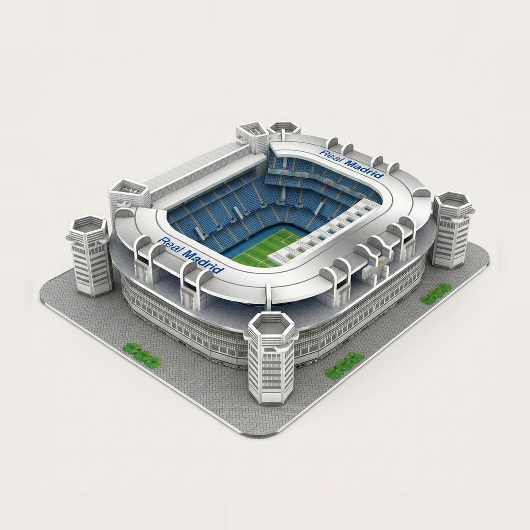 A 3d stadium puzzle with silver walls, blue seating, four corner towers and a green pitch stands against an off-white background.