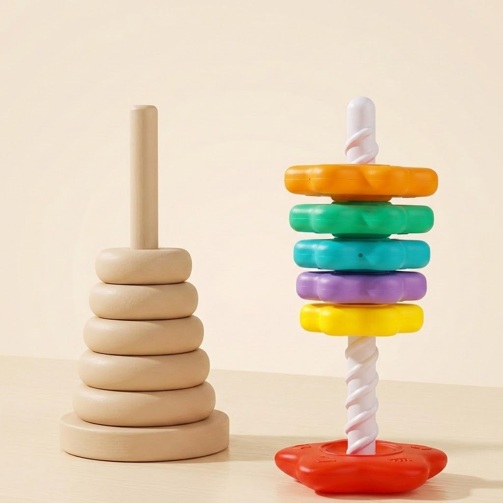 A colourful plastic stacking toy with a white spiral post and red base stands beside a wooden ring tower on a cream surface.