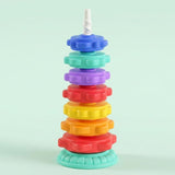 A stacking toy with seven colourful gear-shaped rings, a white spiral post and mint base stands against a pale mint background.
