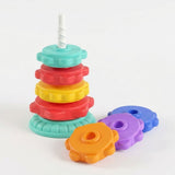 A plastic stacking toy has four colorful discs on a mint base, with orange, purple and blue discs beside it against white.