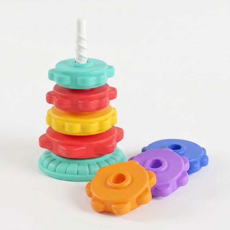 A plastic stacking toy has four colorful discs on a mint base, with orange, purple and blue discs beside it against white.