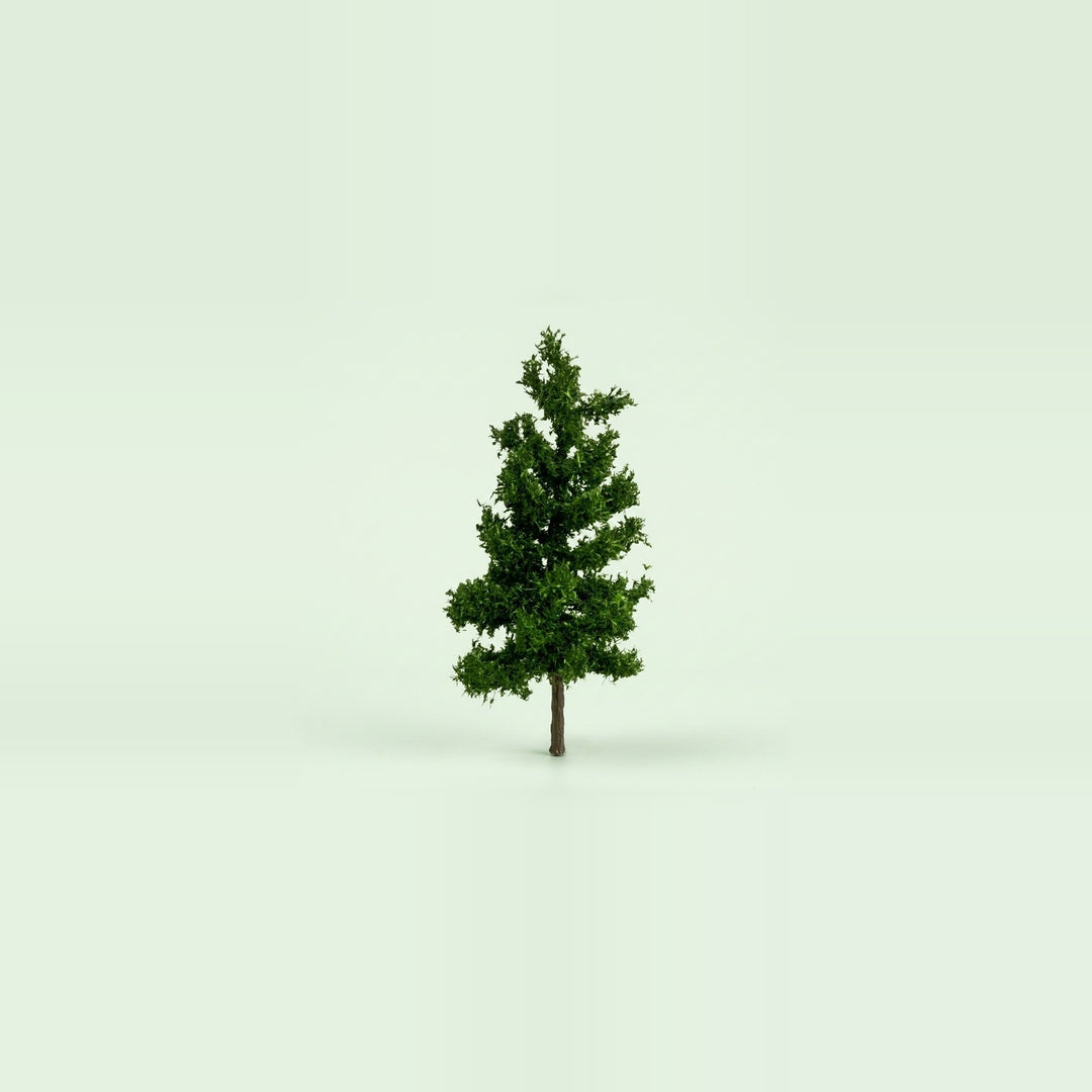 A dark green miniature model pine tree with a slim brown trunk on a pale green studio background, 3.9 inches (10 cm) tall.