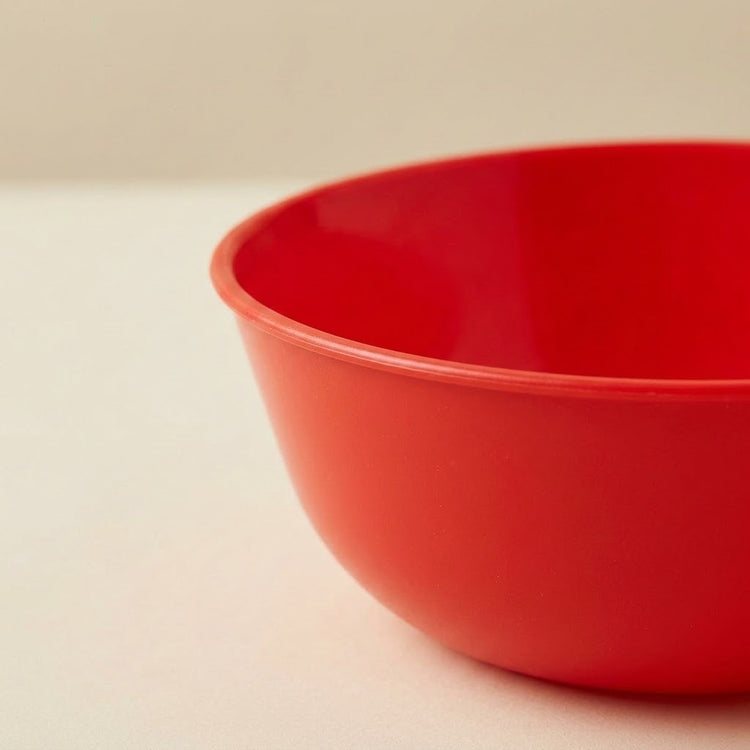 Close-up of the sorting toy set’s red plastic bowl, showing its rounded rim and smooth interior against a beige background.