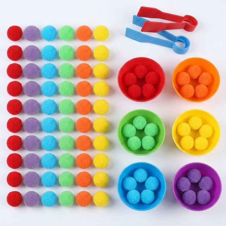 Sorting toy set with rainbow pom-poms in a grid beside six filled plastic bowls and red and blue tweezers on white.