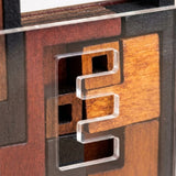 Close-up of the wooden lock puzzle shows reddish-brown and dark mechanism pieces beneath a clear front cover with shaped openings.