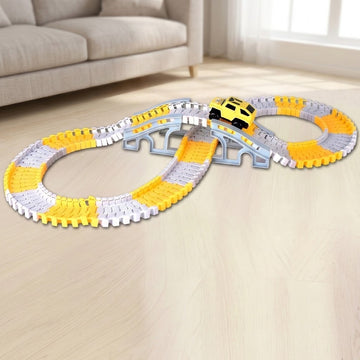 A children's toy train track set with yellow and white curved tracks, a gray bridge, and a small yellow train car, displayed on a light wood floor in a living room setting.
