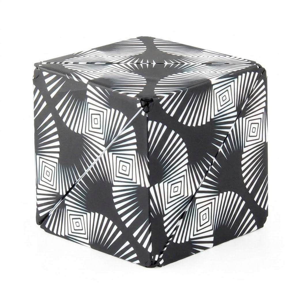 A closed puzzle cube with black and white radiating lines and nested diamond patterns stands against a white background.