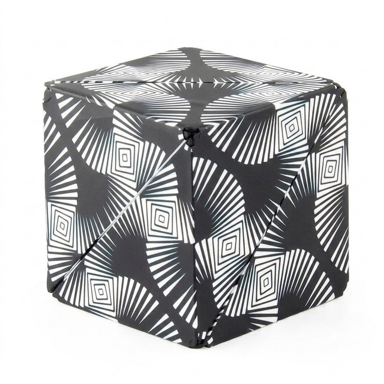 A closed puzzle cube with black and white radiating lines and nested diamond patterns stands against a white background.