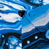A close-up of the blue, white and black marbled puzzle cube shows its plastic panels, diagonal seams and corner detail.