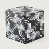 Black and white puzzle cube with radiating lines and nested diamond patterns shown folded closed against a light grey background.