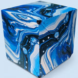 ABS plastic puzzle cube with swirling blue, white, and black marble patterns, shown closed against a pale blue background.