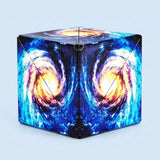 Puzzle cube with blue, turquoise and yellow spiral galaxy patterns shown folded closed against a pale blue background.