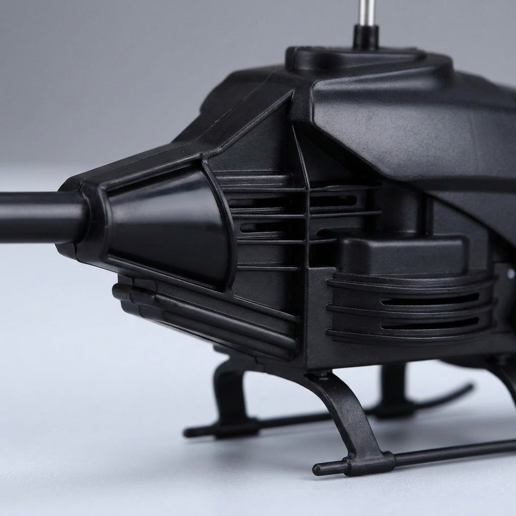 A close-up shows the black remote control helicopter's textured body, side vents, and landing skids against a gray background.