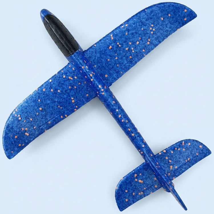 Blue foam toy glider with orange speckles and a black canopy lies diagonally on a light blue background, viewed from above.
