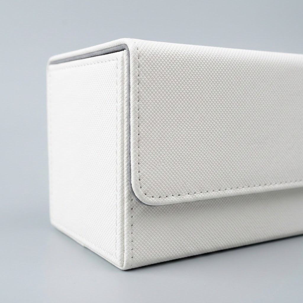 A close view of a white deck box shows its textured exterior, stitched closure flap, and gray edging against a light gray background.