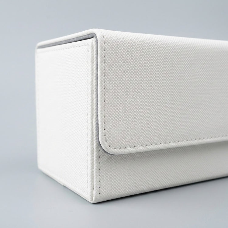 A close view of a white deck box shows its textured exterior, stitched closure flap, and gray edging against a light gray background.