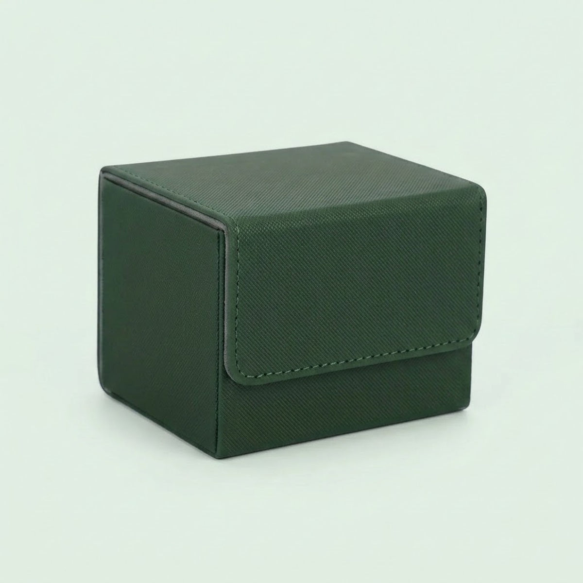 A dark green textured deck box with a closed stitched front flap sits on a pale green background.