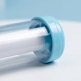 A close-up shows the water gun's clear barrel, white inner tube, and light blue end cap against a pale blue and white background.