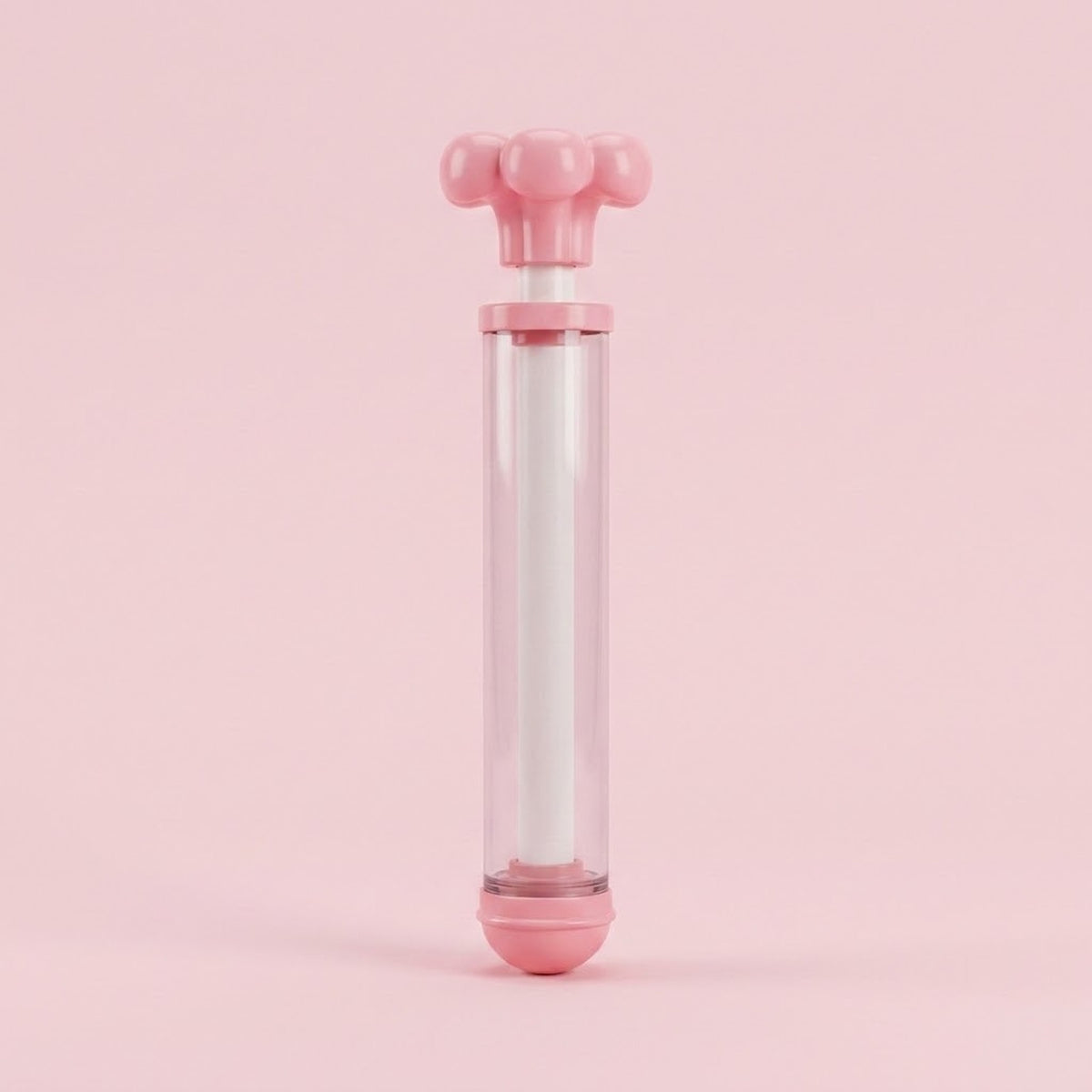 A pink and clear water gun with its flower-shaped handle slightly extended stands upright against a solid pink background.