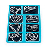Eight-piece silver-colored wire brain teaser set arranged in two columns on a turquoise and black backing card against white.