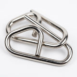 Close-up of interlocking silver-colored geometric loops from the brain teaser set against a white background.