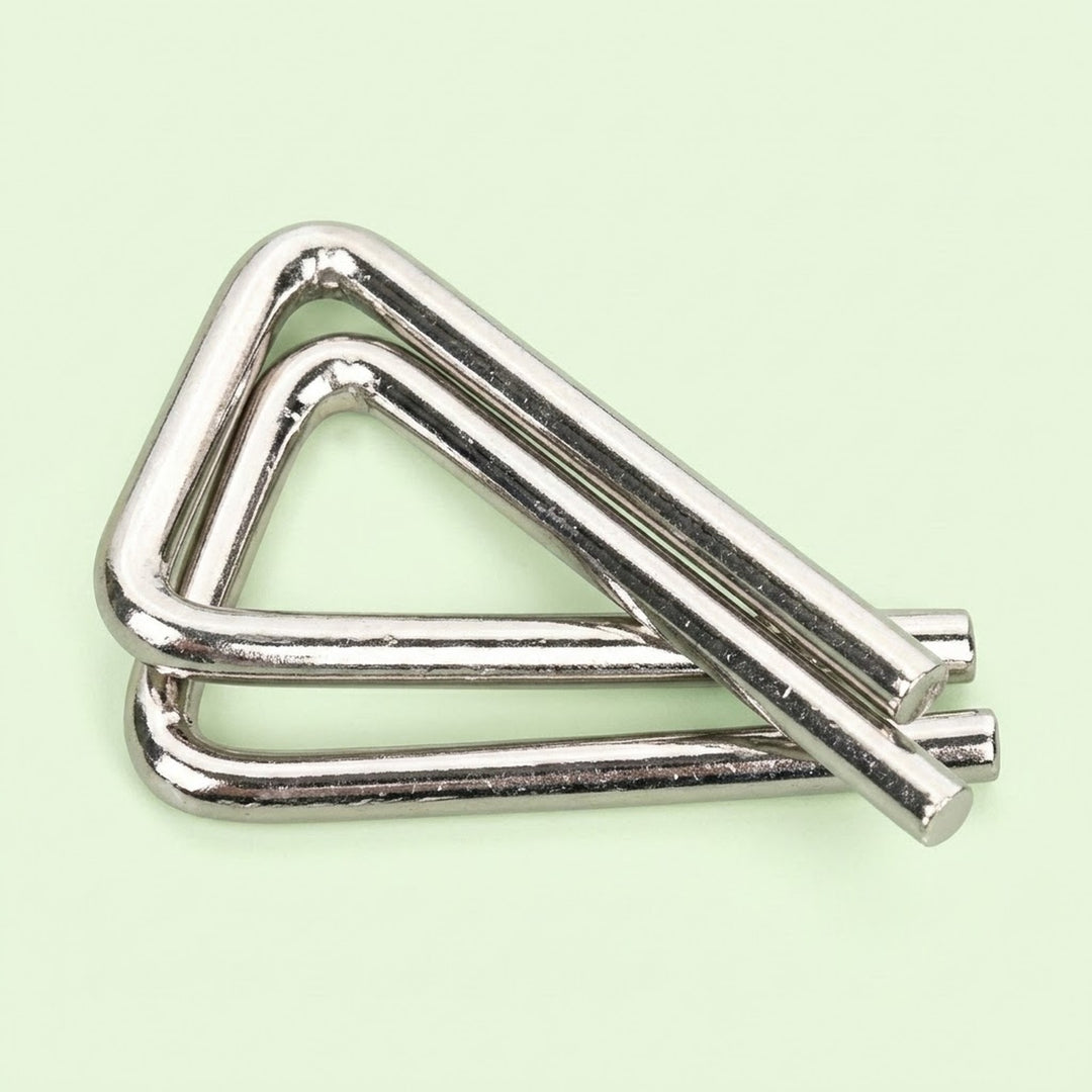 Silver metal triangular puzzle from the brain teaser set, with interlocking bent wires on a pale green background.