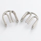 Two separated silver-colored curved wire components from the brain teaser set displayed side by side against a white background.