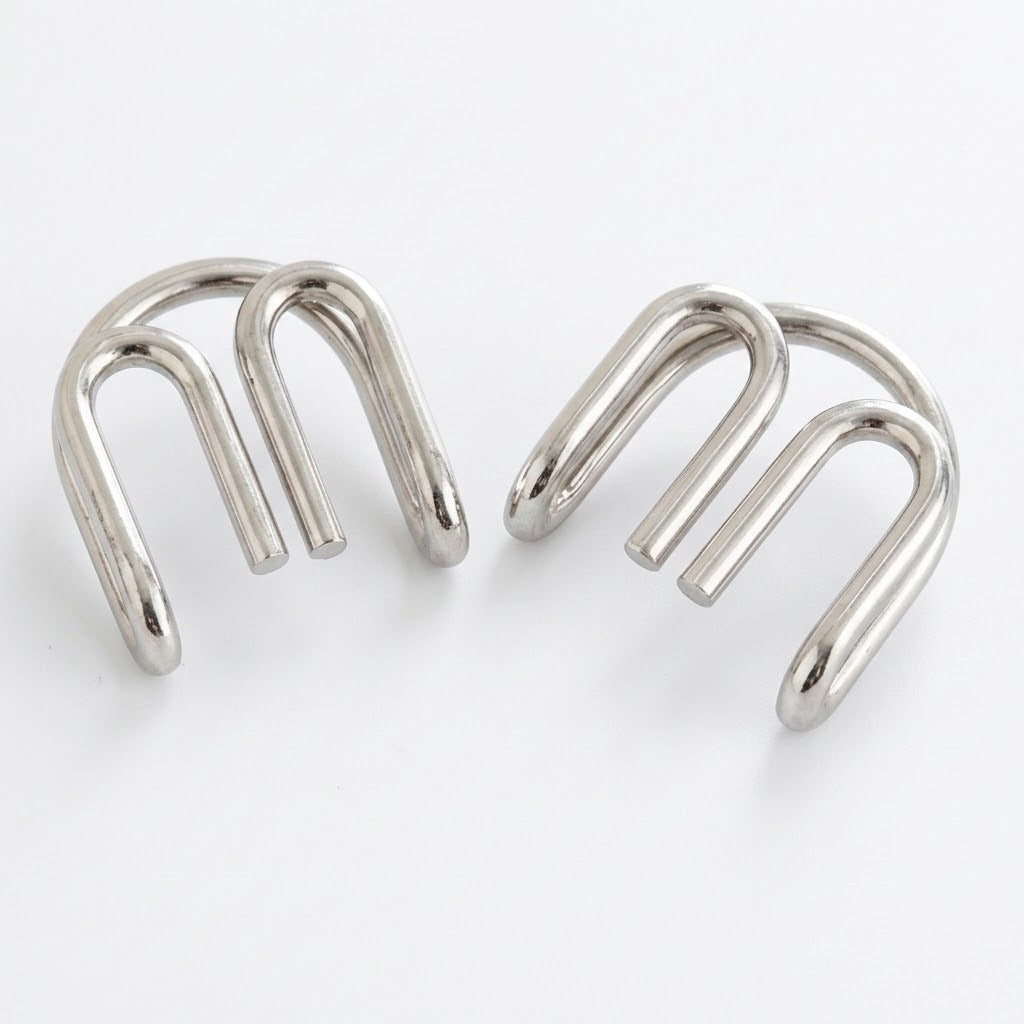 Two separated silver-colored curved wire components from the brain teaser set displayed side by side against a white background.