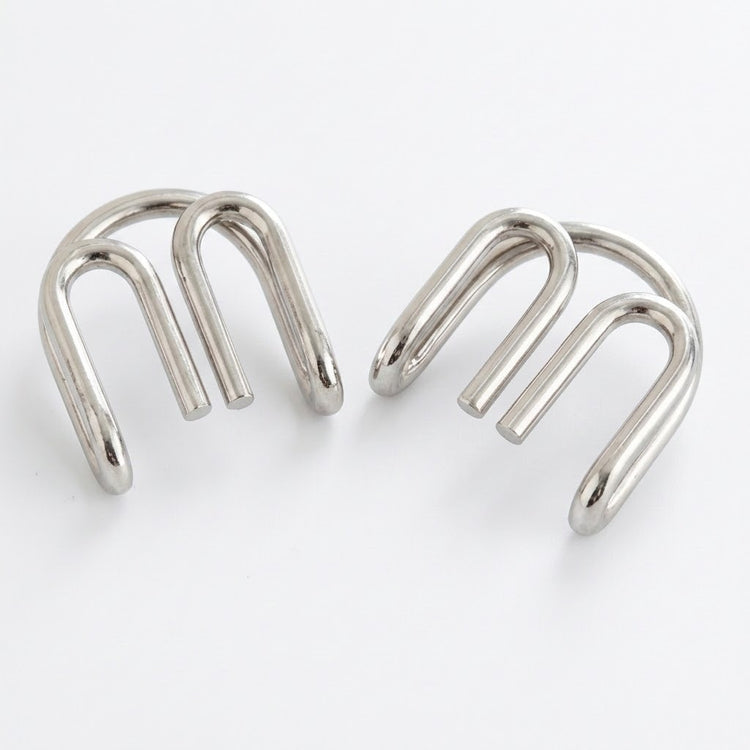 Two separated silver-colored curved wire components from the brain teaser set displayed side by side against a white background.