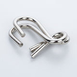 Close-up of a silver-colored interlocking curved wire puzzle from the brain teaser set against a white background.