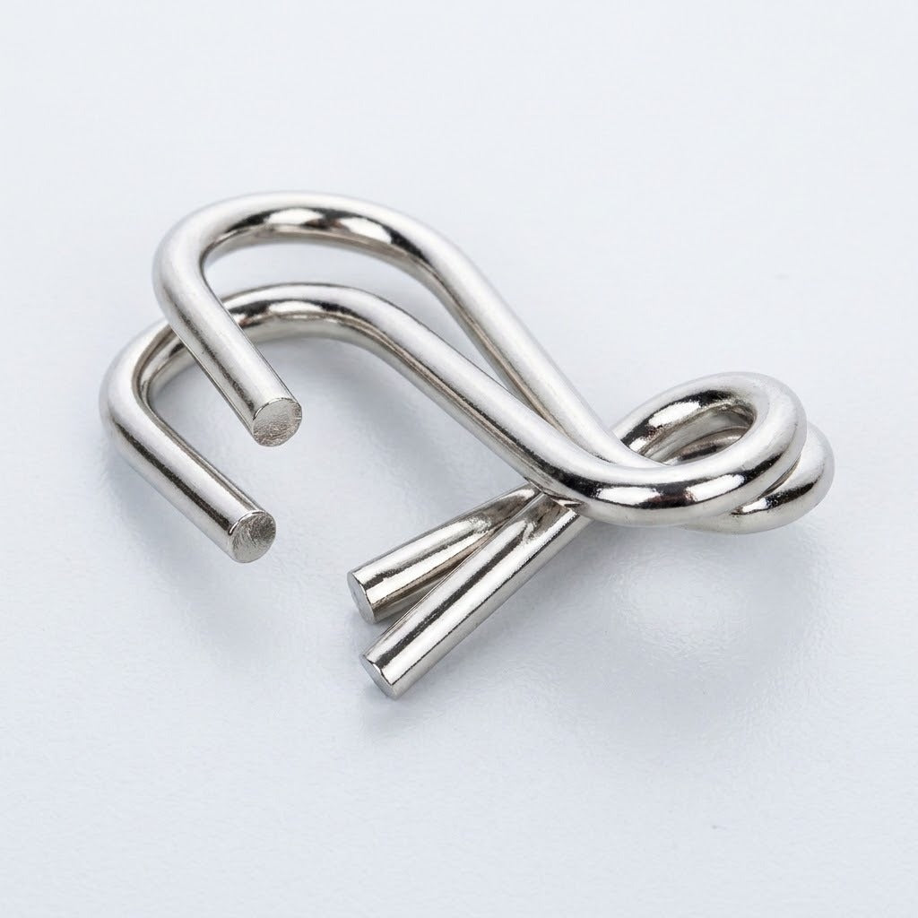 Close-up of a silver-colored interlocking curved wire puzzle from the brain teaser set against a white background.