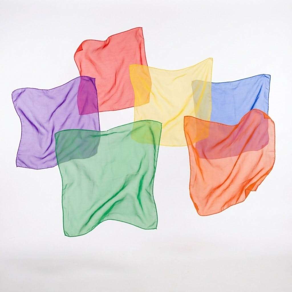 Six translucent chiffon juggling scarves in purple, red, yellow, blue, green and orange form a loose circle against white.
