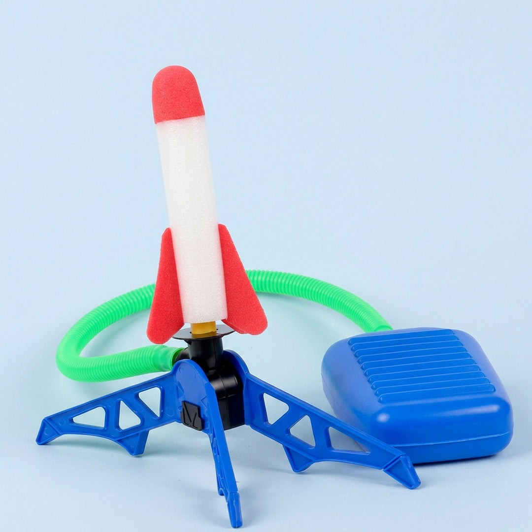 Rocket launcher toy with one red-and-white rocket, blue stand and foot pump, and green hose against a light blue background.