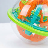 A close-up of the maze puzzle shows its steel ball, teal and orange plastic tracks, clear shell and lime-green rim.