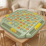 A sage-green memory matching game with yellow fruit and question-mark pieces sits on a wooden table surrounded by chairs.