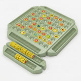 Green memory matching game with yellow fruit tokens and two detached grooved trays holding upright tokens against a white background.