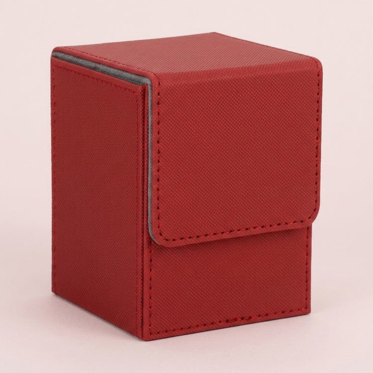 Red textured leather deck box with a fold-over flap and gray piping along the edges, photographed on a plain light background.