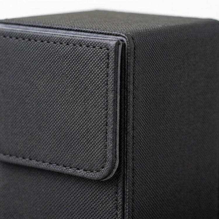 A close-up shows the black textured deck box's upper corner and stitched closure flap against a white background.