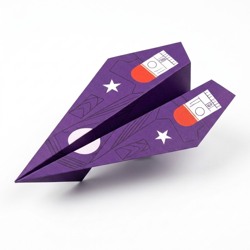Purple paper airplane folded from this origami kit, printed with white stars and red-and-white wing graphics, on a plain white background.