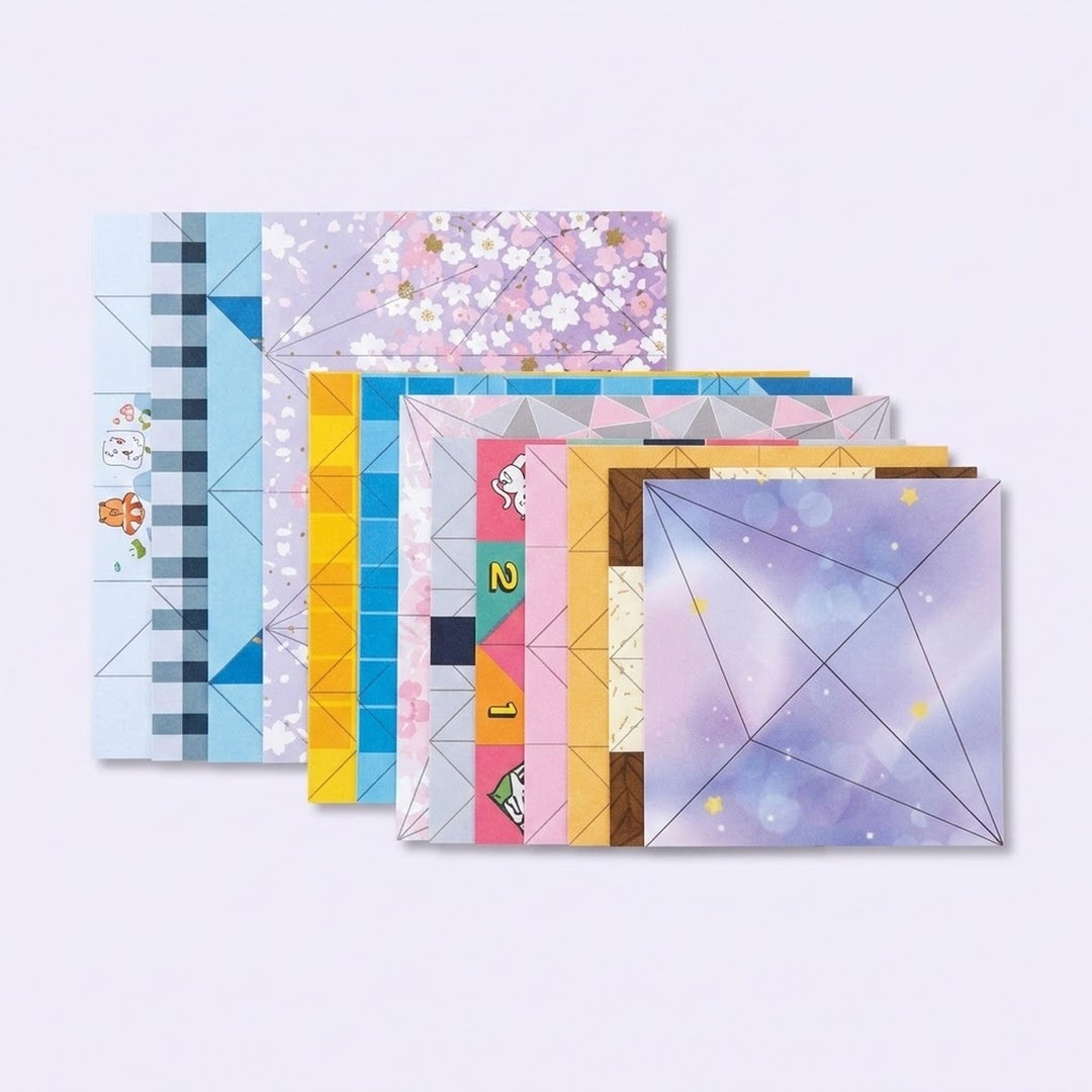 Overlapping origami kit paper sheets feature pastel floral, geometric, and cartoon patterns with printed folding lines on a pale lavender background.