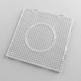 Clear square plastic pegboard with evenly spaced pegs, edge connectors, and a circular central outline on a light grey background.