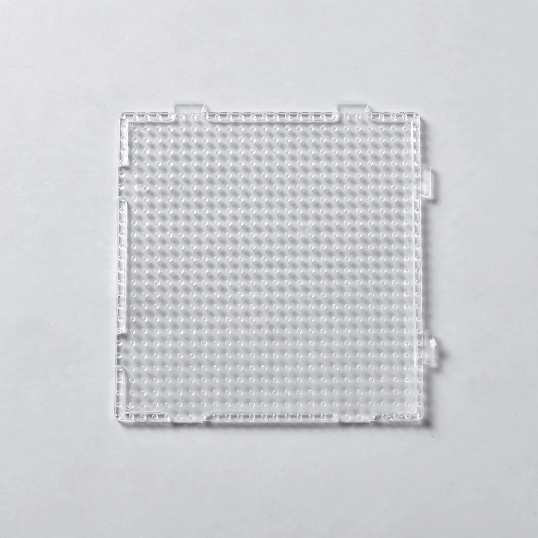 A clear square plastic bead pegboard with interlocking edge tabs is shown from above on a light grey background.