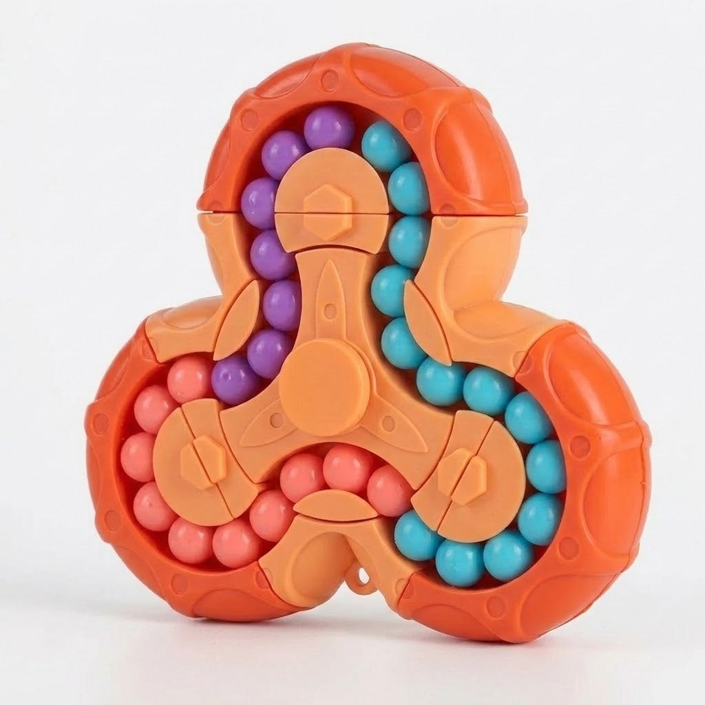 An orange plastic fidget puzzle stands on a white surface with purple, turquoise and coral beads arranged along curved tracks.