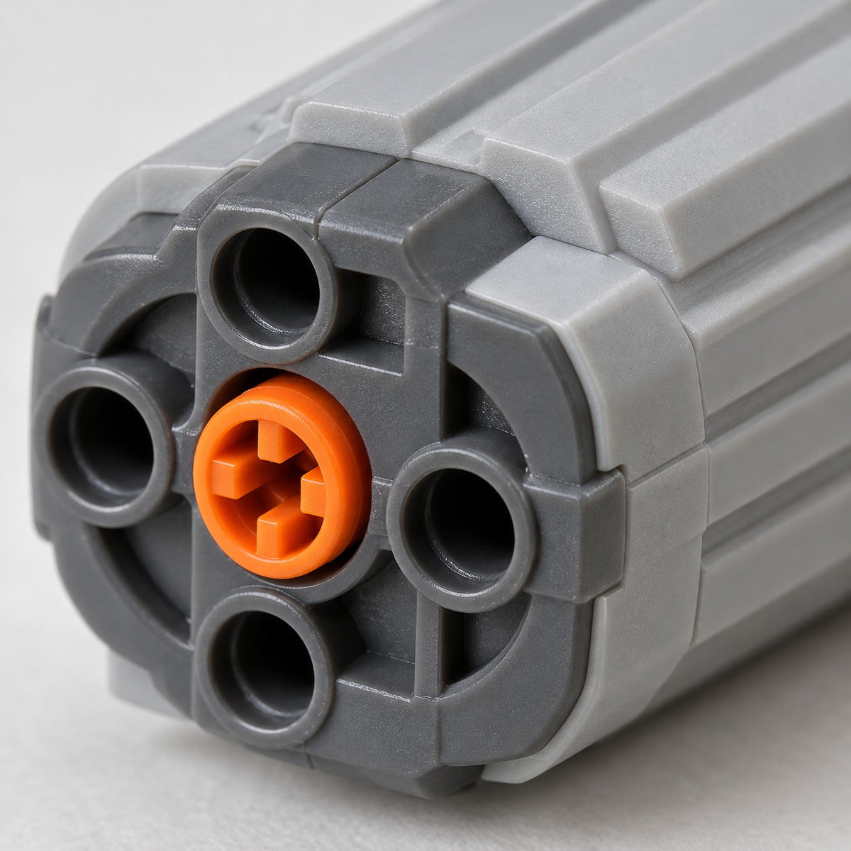 Macro detail of the MOC Power Functions motor's ribbed gray plastic housing and orange connector.