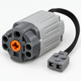 The MOC Power Functions motor shows its compact ribbed housing, orange shaft connector and attached wire.