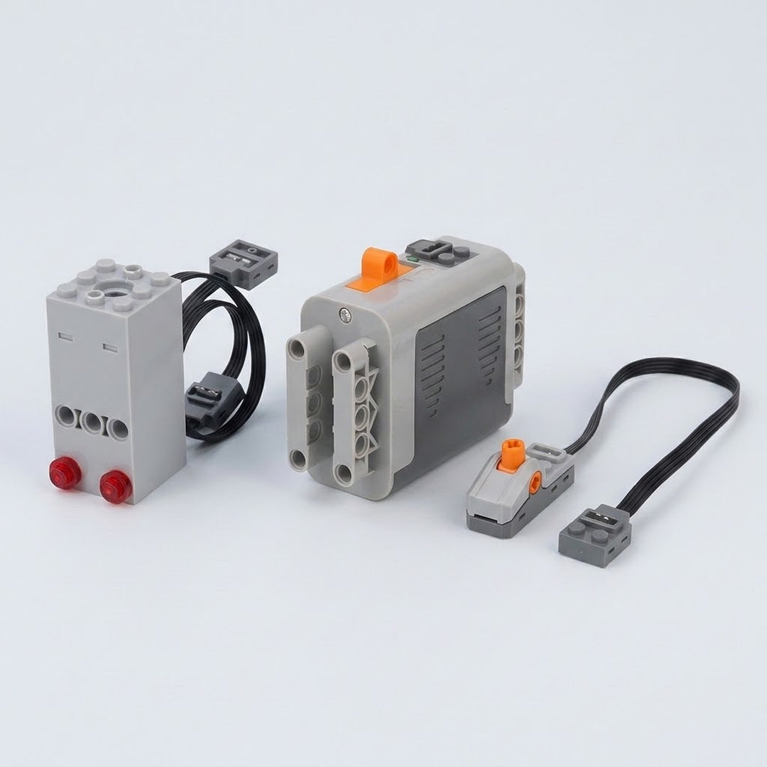 A gray plastic model exhaust sprayer with two red lenses sits beside a ribbed battery case and orange-control switch on white.