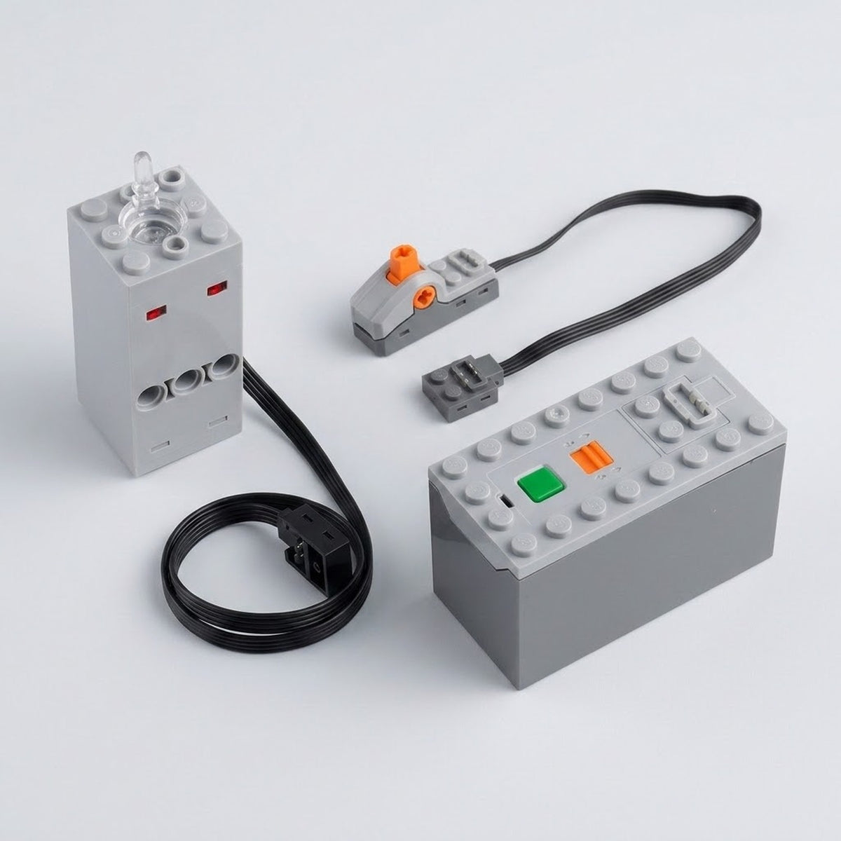 A gray model exhaust sprayer sits beside a battery case with green and orange controls, wired switch, and black cables on white.