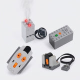 A gray model exhaust sprayer emits mist beside a battery case, orange-button remote, and wired receiver on a white background.